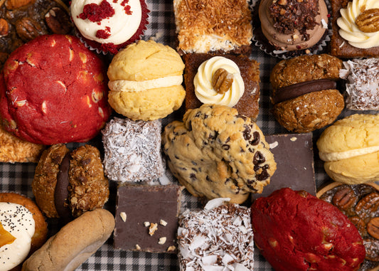 A box of a variety of home baked goods, including biscuits, cakes & lamingtons